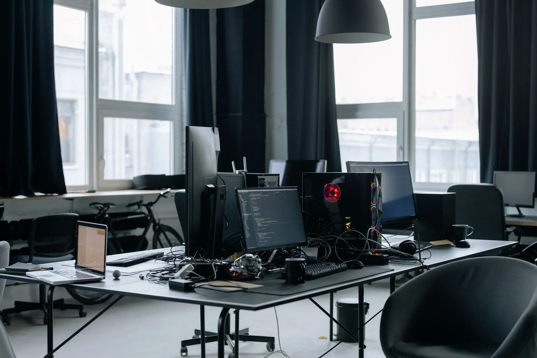 A contemporary workspace with computers showing code and office essentials.